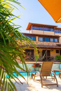 a building with a table and chairs next to a pool at Dunas de Itaipu in Niterói