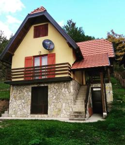 une petite maison avec un toit rouge dans l'établissement Vila Mitrović, à Bajina Bašta