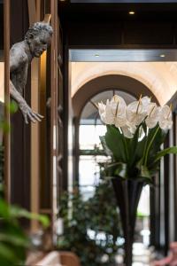 Umiltà 36 في روما: مزهرية مع الزهور البيضاء في غرفة مع تمثال