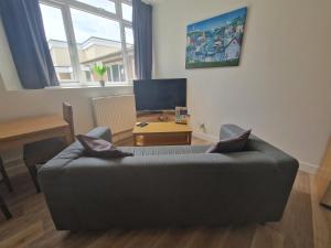 a living room with a couch and a table at Direct Booking Prices, Studio Apartment, Free Parking, Wifi, Central, Quiet in Exeter