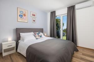 sypialnia z dużym łóżkiem i oknem w obiekcie Villa Mirjam with swimming pool, jacuzzi and sea view w Novim Vinodolskim +37 zdjęć
