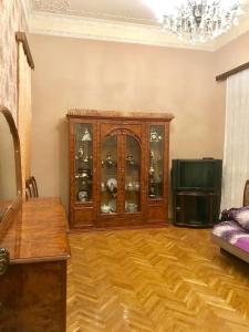 a living room with a china cabinet and a television at Cozy, large apartment in the heart of city center in Baku