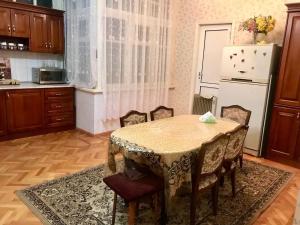 a kitchen with a table with chairs and a refrigerator at Cozy, large apartment in the heart of city center in Baku