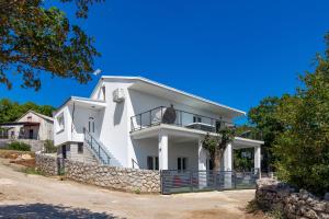 Biały dom z kamienną ścianą w obiekcie Villa Mirjam with swimming pool, jacuzzi and sea view w Novim Vinodolskim