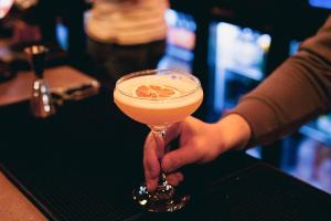 una persona che tiene un drink in un bicchiere di Martini di Jacobs Inn Dublin a Dublino