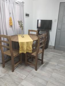 mesa de comedor y sillas con mesa y TV en El RANCHO en San Martín