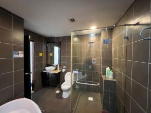 a bathroom with a toilet and a glass shower at Gold Coast Morib by Tim in Morib
