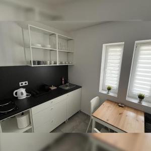 eine Küche mit weißen Schränken und einem Holztisch in der Unterkunft Apartmán Markéta in Lipno nad Vltavou