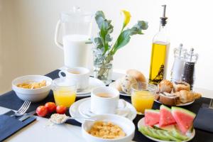 a breakfast table with cups and plates of food and drinks at Casual del Mar Málaga in Málaga