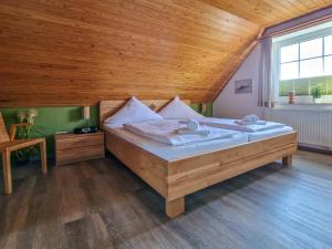 ein großes Bett in einem Zimmer mit Holzdecke in der Unterkunft Birgits Huus in Greetsiel