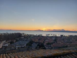 a view of a city with the sunset in the background at Casa Rosita vista lago in Bolsena