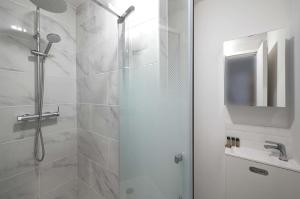 a white bathroom with a shower and a sink at Sublime appartement -Versailles in Versailles