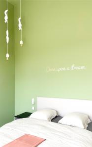 Hooglede的住宿－Fluwine，卧室配有白色的床和绿色的墙壁