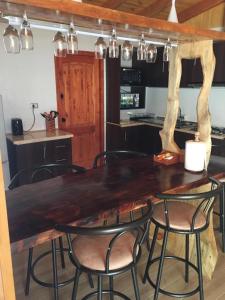 プコンにあるcabañas anvi puconのキッチン(大きな木製テーブル、椅子付)