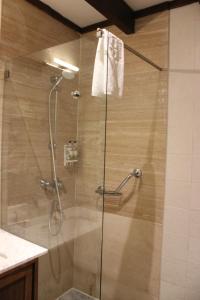 La salle de bains est pourvue d'une douche avec une porte en verre. dans l'établissement Topazio Vibe Beach Hotel & Apartments - Adults Friendly, à Albufeira