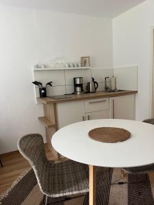 a white table and chairs in a kitchen at Deich Quartier 9.3 in Dorum Neufeld