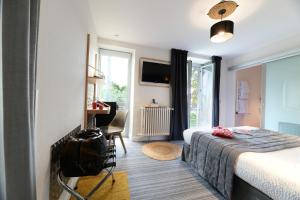 a hotel room with a bed with a backpack on the floor at Hôtel Le Loft in Trie sur Baise