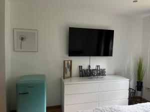 a bedroom with a dresser with a tv on the wall at Deich Quartier 9.3 in Dorum Neufeld