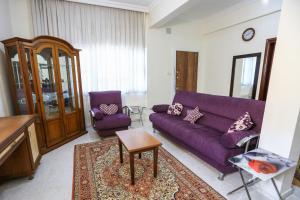 een woonkamer met een paarse bank en een piano bij İzol Apart Evleri Adrasan in Kumluca
