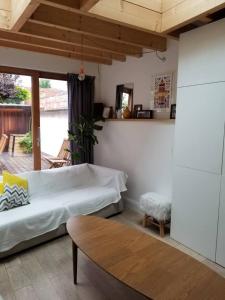 a bedroom with a bed and a table and a window at Maison hypercentre calme, terrasse, garage, poêle in Clermont-Ferrand