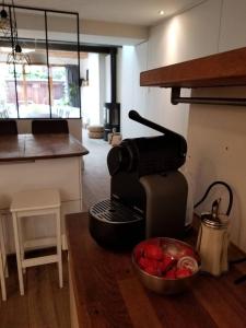 - une cafetière et une corbeille de fruits sur un comptoir dans l'établissement Maison hypercentre calme, terrasse, garage, poêle, à Clermont-Ferrand