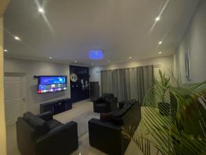 a living room with two couches and a flat screen tv at Illovo Beach house in Amanzimtoti