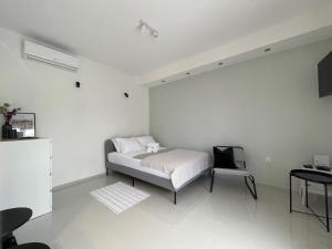1 dormitorio blanco con 1 cama y 1 silla en Studio D2, en Biograd na Moru