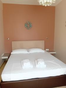 a white bed with two towels on top of it at Beauty Thessaloniki Apartment in Thessaloniki