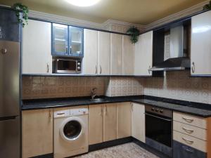 a kitchen with white cabinets and a washing machine at apartamento centro in Vitoria-Gasteiz