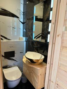 a bathroom with a sink and a toilet and a mirror at Roomflacja Bałtyk in Sianozety