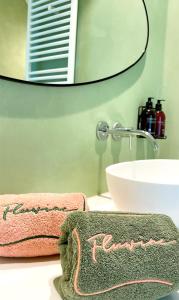 een badkamer met een wastafel, een spiegel en handdoeken bij Fluwine in Hooglede