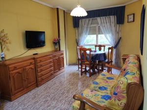 a living room with a couch and a tv and a table at apartamento centro in Vitoria-Gasteiz
