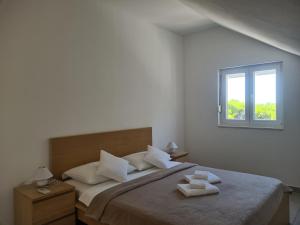 a bedroom with a bed with two white towels on it at Apartments Toro in Sveta Nedelja