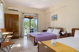 a hotel room with two beds and a balcony at Vardia studio B in Mikros Gialos
