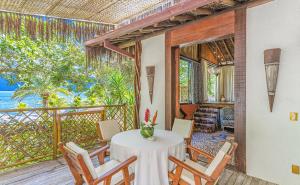 a room with a table and chairs on a balcony at DPNY Beach Hotel & SPA Ilhabela in Ilhabela