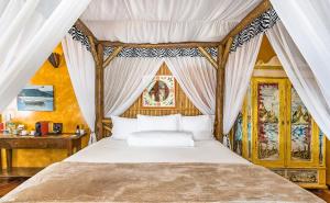a bedroom with a canopy bed and a desk at DPNY Beach Hotel & SPA Ilhabela in Ilhabela +131 photos