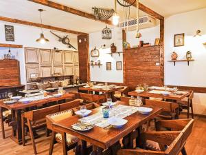 een eetkamer met houten tafels en stoelen bij Etno Garden Exclusive Rooms in Plitvica selo