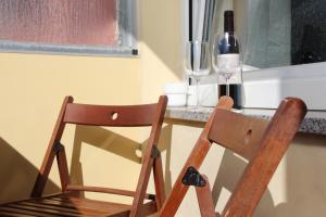 uma cadeira de madeira ao lado de uma mesa com copos de vinho em Šiška Deluxe em Ljubljana