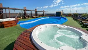 uma banheira de hidromassagem num deque ao lado de uma piscina em Grand Crucero Hotel em Porto Iguaçu