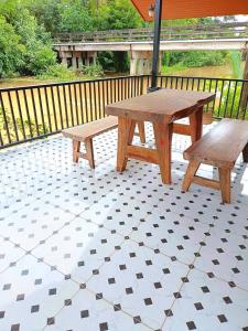 a picnic table and two benches on a patio at Amantra homestay & village in Suratthani