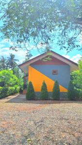 a house with a yellow and blue wall at Amantra homestay & village in Surat Thani