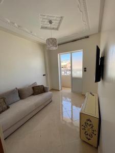 アガディールにあるLogement entier : Appartement à Agadirのリビングルーム(ソファ付)が備わり、海の景色を望めます。