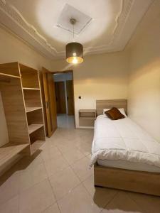 a bedroom with a bed and a book shelf at Logement entier : Appartement à Agadir in Agadir