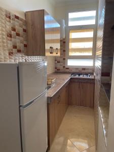 a kitchen with a white refrigerator and a window at Logement entier : Appartement à Agadir in Agadir