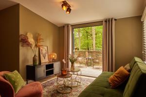 salon z zieloną kanapą i patio w obiekcie Luxe hippe Lodge in de bossen van Oisterwijk w mieście Oisterwijk