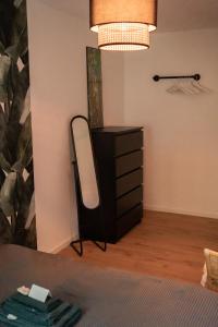 a bedroom with a mirror and a dresser and a lamp at MOREHOME-Apartments in Mindelheim