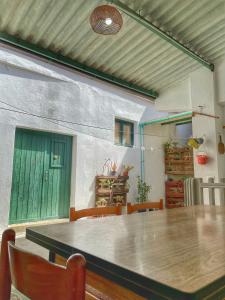 einen großen Tisch in einem Zimmer mit grüner Tür in der Unterkunft Casa Nina in Gonnesa