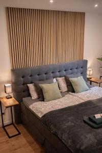 a bedroom with a large bed with a blue headboard at MOREHOME-Apartments in Mindelheim
