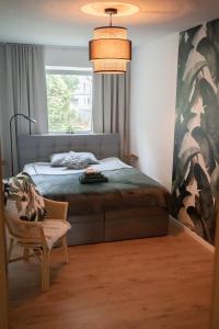 a bedroom with a bed and a window and a chair at MOREHOME-Apartments in Mindelheim