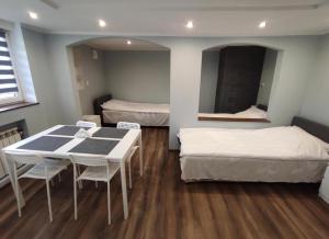 a room with two beds and a table and chairs at Agroturystyka Huta in Krzywe +41 photos